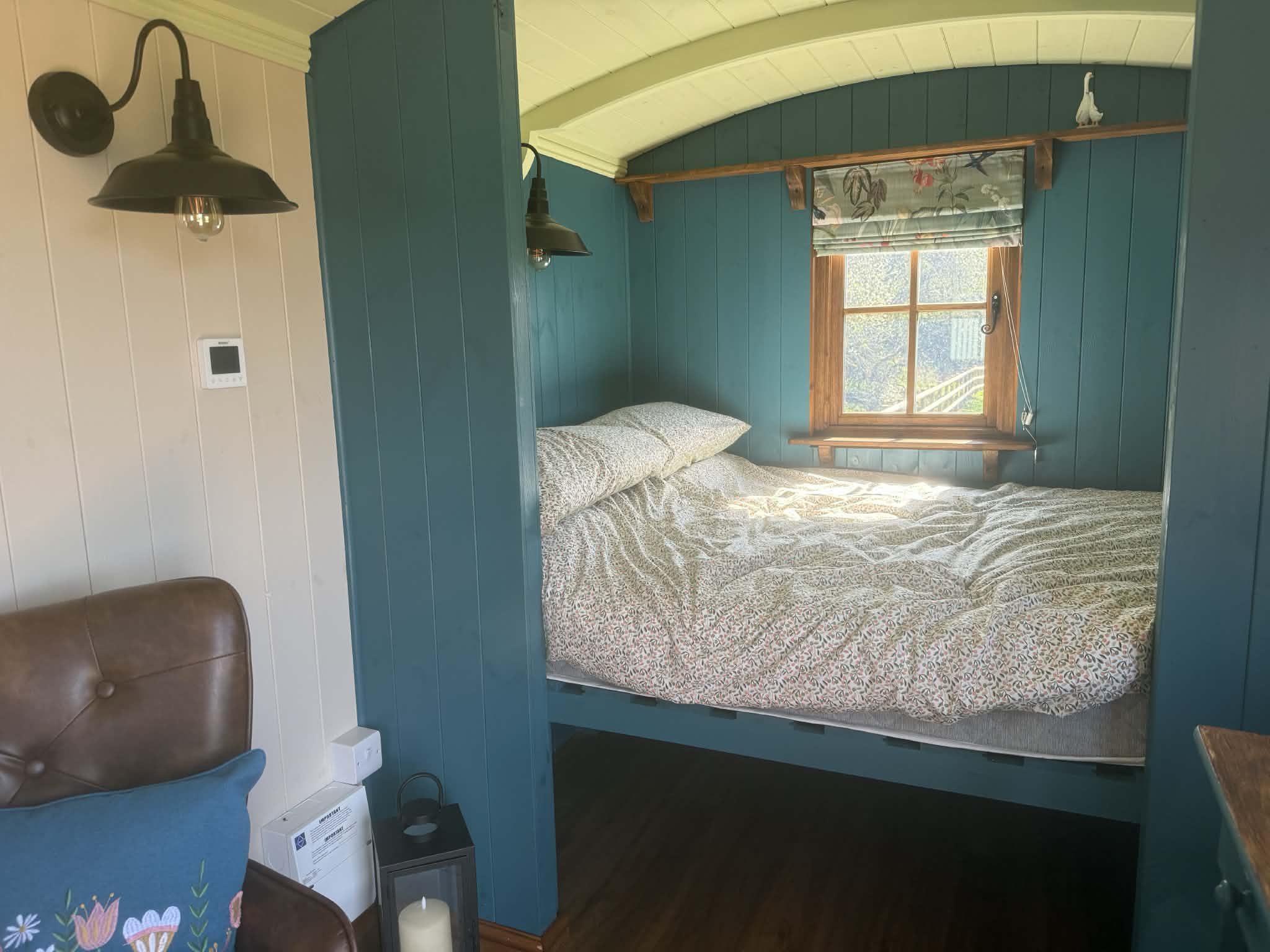 Exterior view of the shepherd hut nestled in the green Welsh valley